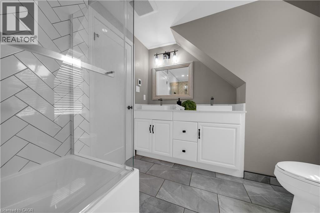 Bathroom featuring a dual vanity with white cabinetry and black hardware - 26 Peachtree Crescent, Cambridge, ON - Indoor Photo Showing Bathroom