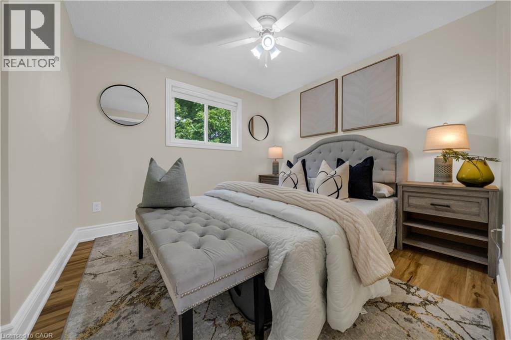 Bedroom featuring neutral wall tones, wood-finish flooring, a white window frame, and a ceiling fan with integrated lighting - 26 Peachtree Crescent, Cambridge, ON - Indoor Photo Showing Bedroom