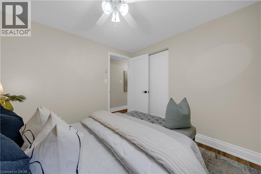 Bedroom featuring light neutral wall paint, wood-finish flooring, white baseboards, and a white ceiling fan with integrated lighting - 26 Peachtree Crescent, Cambridge, ON - Indoor Photo Showing Bedroom