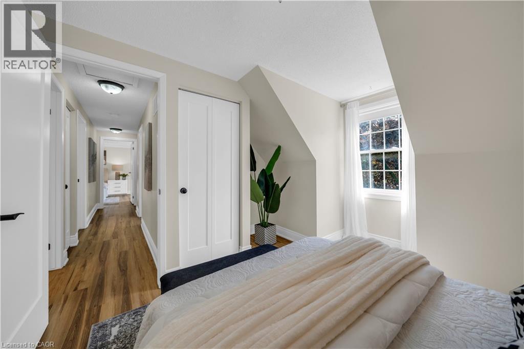Bedroom featuring an angled ceiling, a double-hung window with white trim, a bi-fold closet door, and light-toned walls - 26 Peachtree Crescent, Cambridge, ON - Indoor Photo Showing Bedroom
