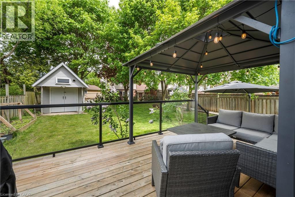 Wood-finish deck featuring a glass railing and a permanent gazebo with integrated string lighting - 26 Peachtree Crescent, Cambridge, ON - Outdoor With Deck Patio Veranda With Exterior