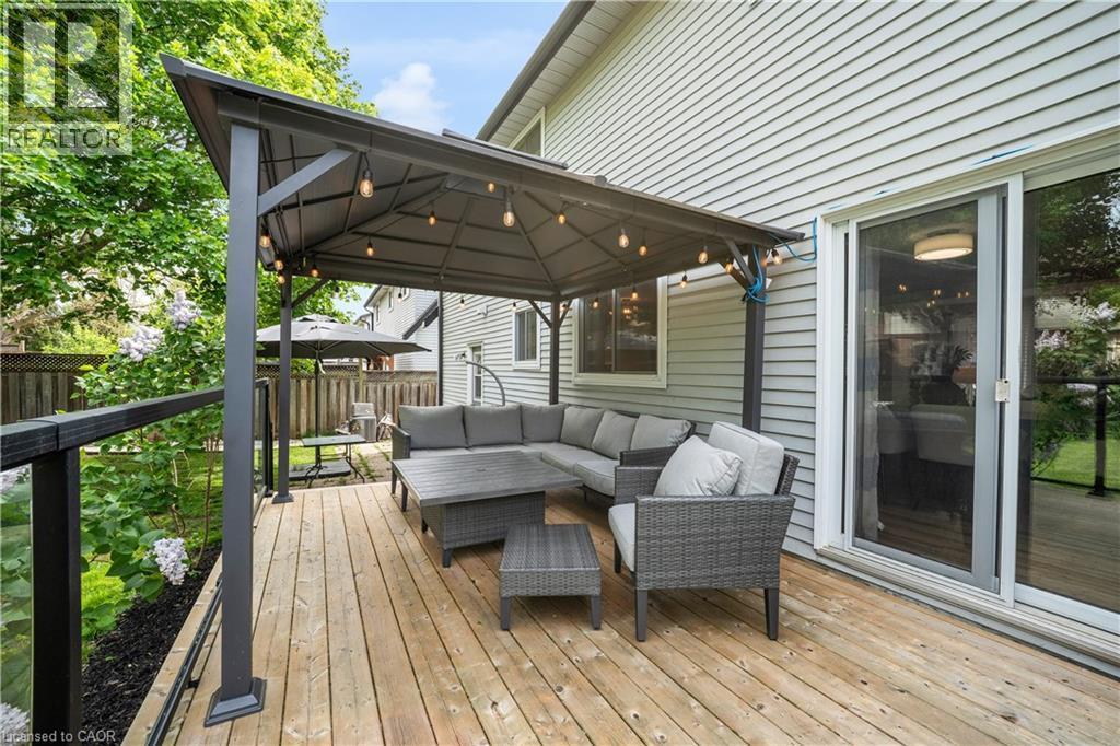 Expansive wooden deck featuring a built-in gazebo with string lighting, glass panel railings, and a sliding glass door entry to the home - 26 Peachtree Crescent, Cambridge, ON - Outdoor With Deck Patio Veranda With Exterior
