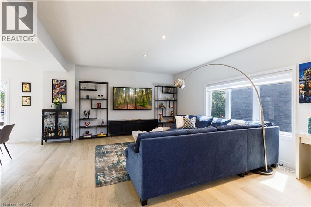 Spacious living area featuring light wood-finish flooring, recessed lighting, and large windows providing ample natural light - 581 Doonwoods Crescent, Kitchener, ON - Indoor Photo Showing Living Room