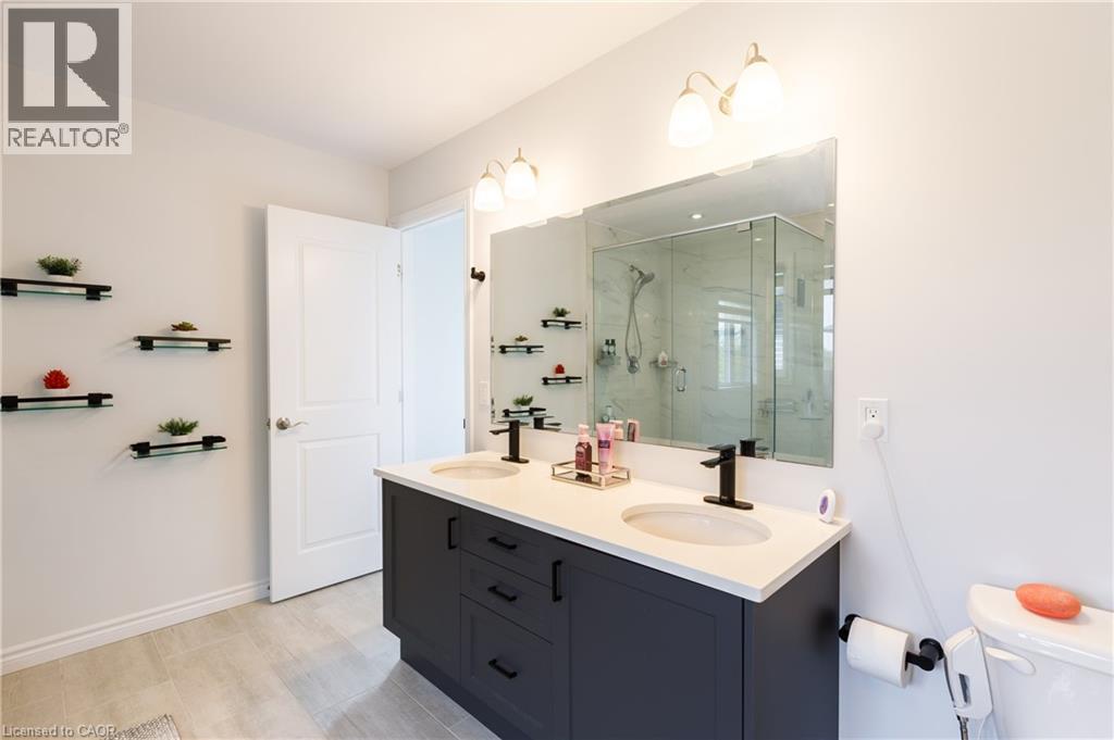 Double vanity with stone-finish countertop, undermount sinks, and matte black fixtures - 581 Doonwoods Crescent, Kitchener, ON - Indoor Photo Showing Bathroom