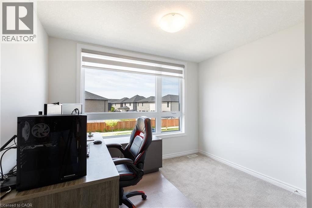 Bright room featuring a large window with roller shades, light grey carpet, white baseboards, and a flush mount ceiling light - 581 Doonwoods Crescent, Kitchener, ON - Indoor Photo Showing Office