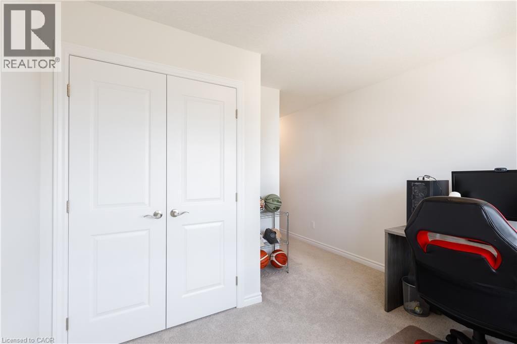 Double panel doors with lever hardware, light-colored carpeting, white baseboards, and neutral wall tones - 581 Doonwoods Crescent, Kitchener, ON - Indoor