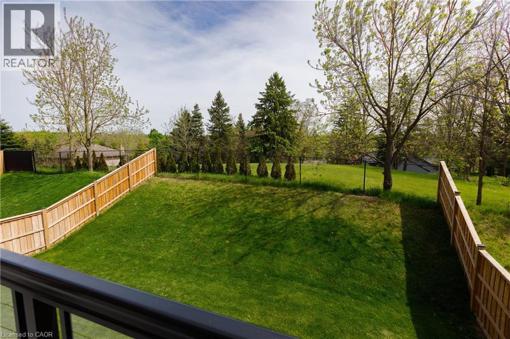Expansive green lawn with a newly installed wood privacy fence and mature trees - 581 Doonwoods Crescent, Kitchener, ON - Outdoor