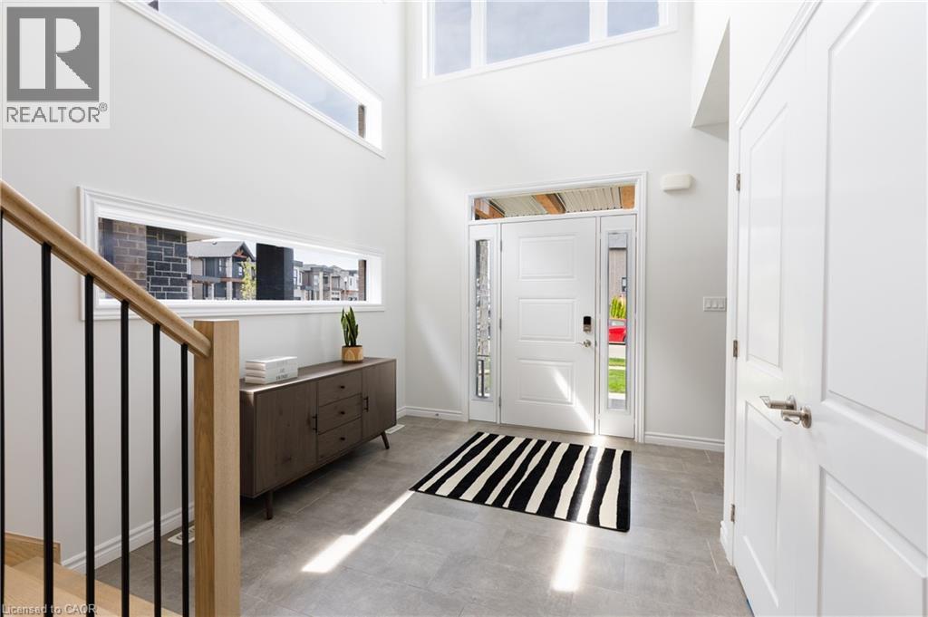 Bright entryway featuring a high ceiling, transom windows, and a panel-style front door with sidelights - 581 Doonwoods Crescent, Kitchener, ON - Indoor Photo Showing Other Room