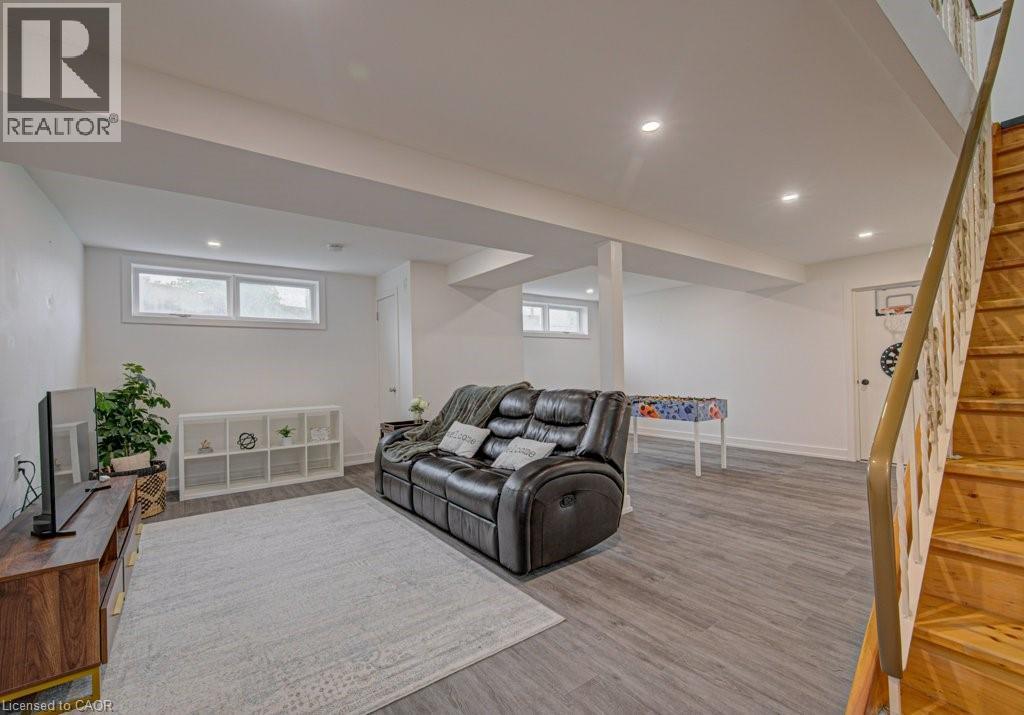 Spacious finished basement featuring recessed lighting, light wood-finish flooring, and multiple windows - 128 Pollock Avenue, Cambridge, ON - Indoor Photo Showing Basement