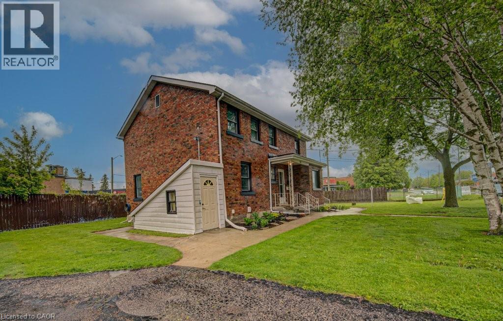 Brick exterior residence with a covered front porch featuring white railings - 128 Pollock Avenue, Cambridge, ON - Outdoor