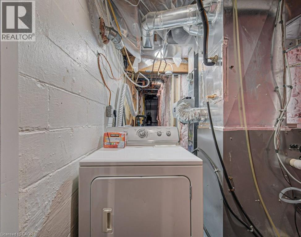Utility space featuring a dryer appliance, painted cinder block walls, and exposed ductwork - 128 Pollock Avenue, Cambridge, ON - Indoor Photo Showing Laundry Room