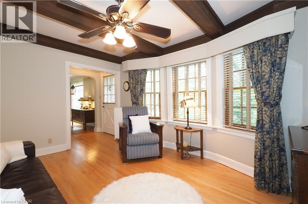 Warm and inviting room featuring wood-finish flooring, a ceiling fan with light fixture, and exposed ceiling beams - 2023 Coronation Boulevard, Cambridge, ON - Indoor