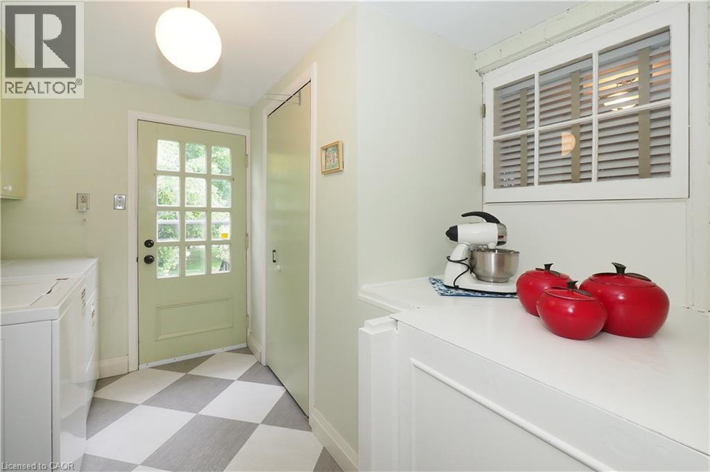Utility space featuring a checkerboard floor, a multi-pane glass door, and a built-in window with horizontal blinds - 2023 Coronation Boulevard, Cambridge, ON - Indoor Photo Showing Laundry Room