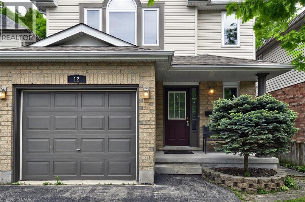 Brick and siding facade featuring an attached garage with a panel door, covered entryway, and an arched window on the upper level - 12 Karalee Crescent, Cambridge, ON - Outdoor