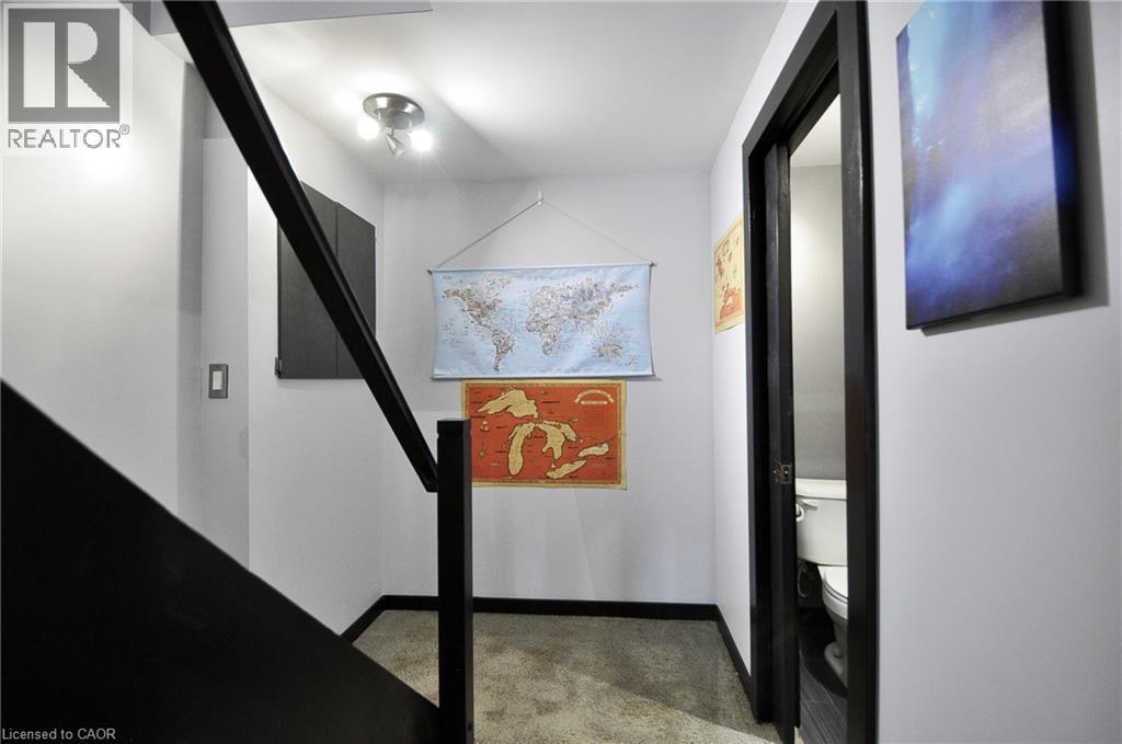 Staircase with dark-finish handrail, contemporary track lighting, light gray walls, and dark-finish baseboards - 12 Karalee Crescent, Cambridge, ON - Indoor Photo Showing Other Room