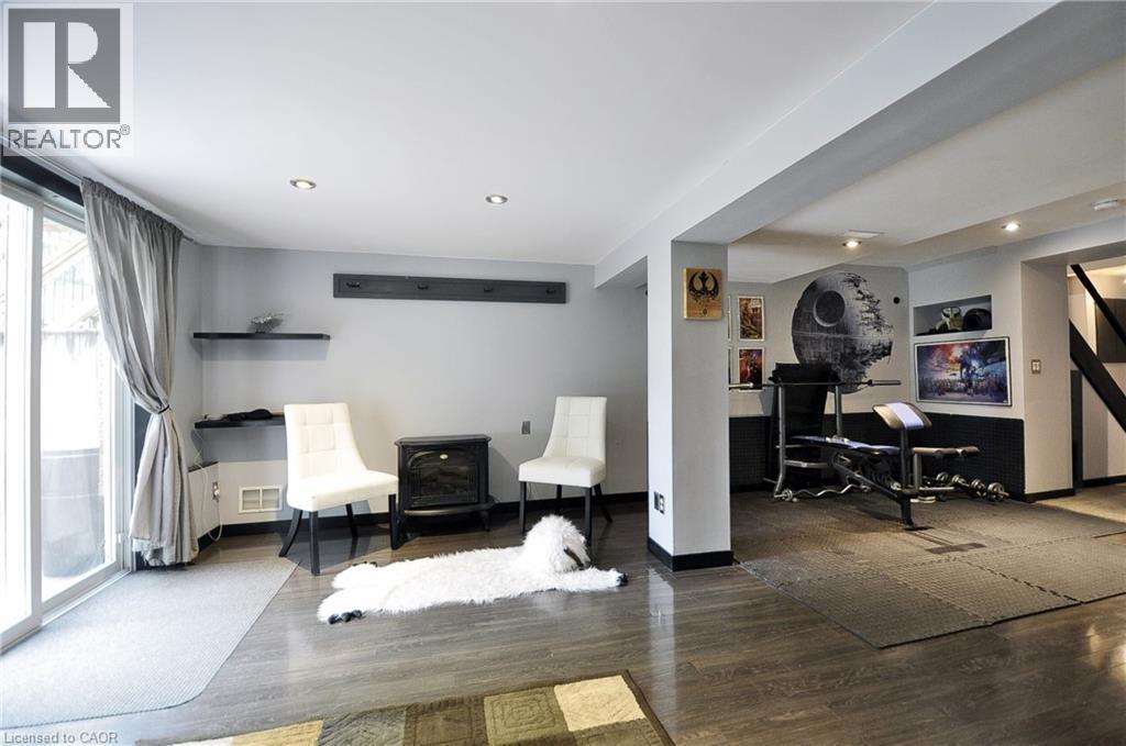 Lower level space featuring wood-finish flooring, recessed lighting, and sliding glass door access - 12 Karalee Crescent, Cambridge, ON - Indoor