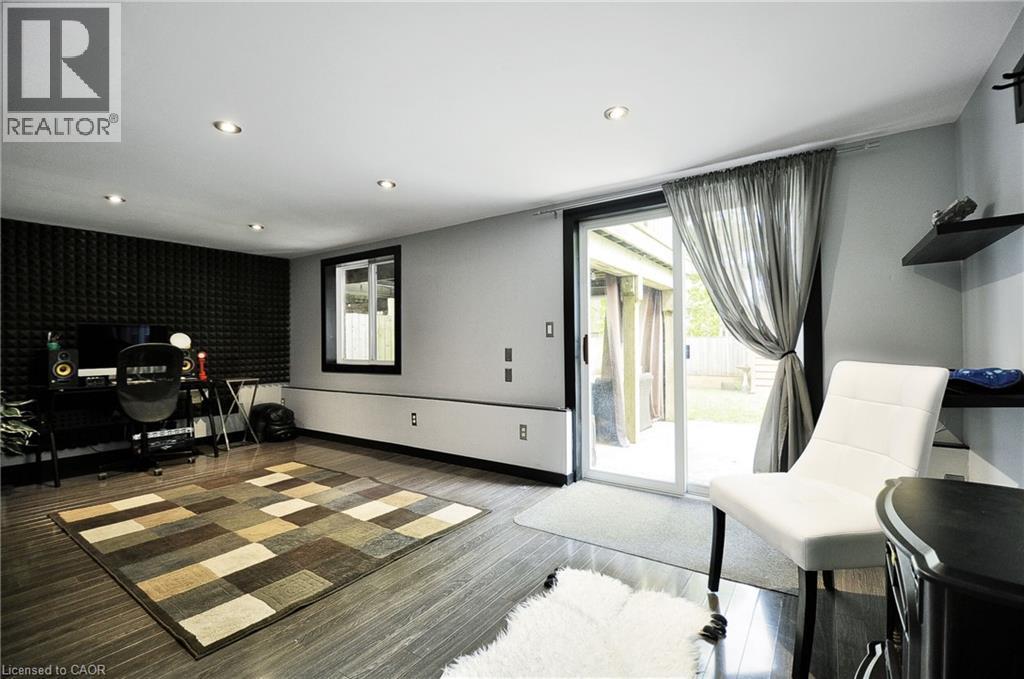 Spacious room featuring wood-finish flooring, recessed ceiling lighting, and a wall of acoustic paneling - 12 Karalee Crescent, Cambridge, ON - Indoor