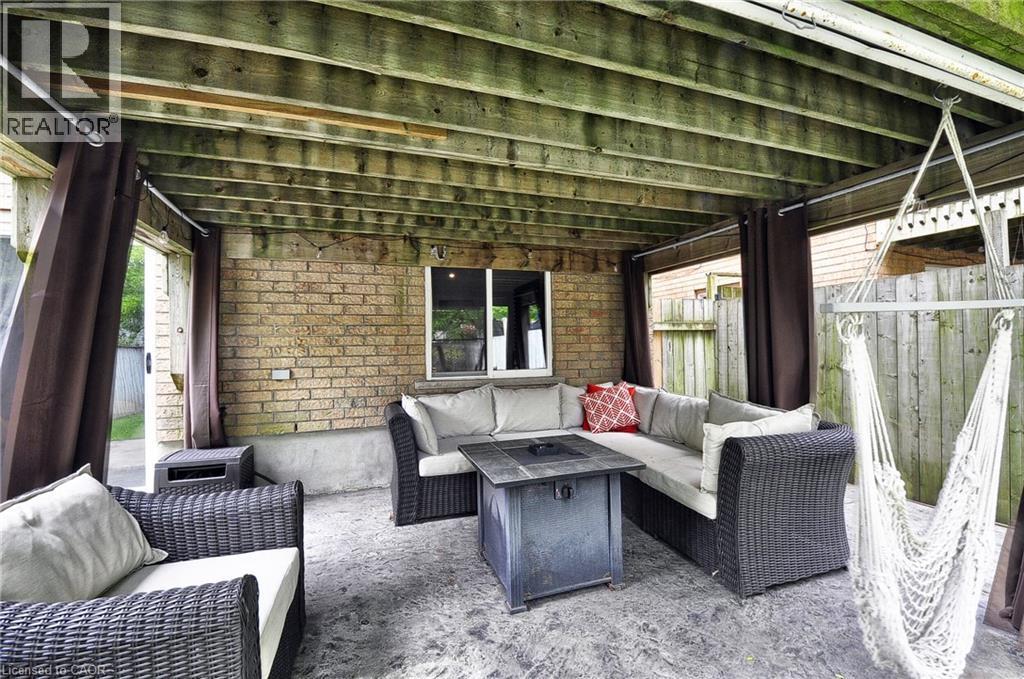 Covered outdoor patio area featuring a concrete slab foundation, a wood-slatted ceiling, and brick exterior wall - 12 Karalee Crescent, Cambridge, ON - Outdoor With Deck Patio Veranda With Exterior