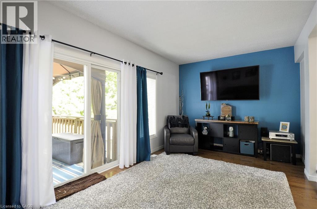 Living area featuring wood-finish flooring and a distinctive accent wall - 12 Karalee Crescent, Cambridge, ON - Indoor Photo Showing Bedroom