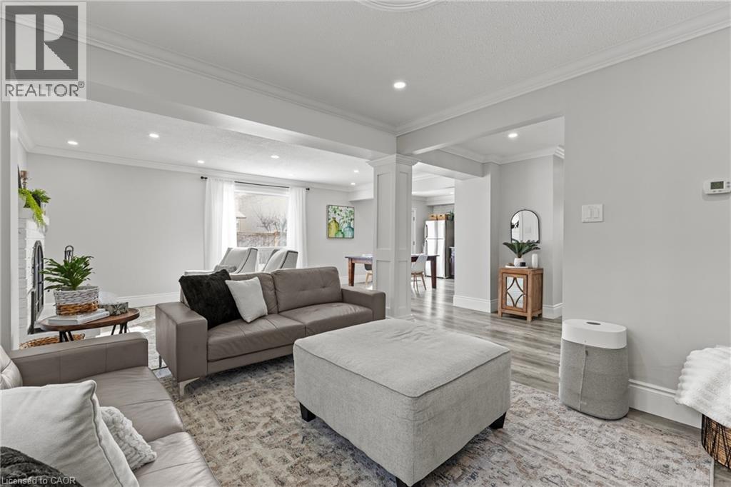 Spacious living area featuring light-toned wood-finish flooring, recessed lighting, crown molding, and white baseboards - 27 Barbara Court, Hamilton, ON - Indoor Photo Showing Living Room