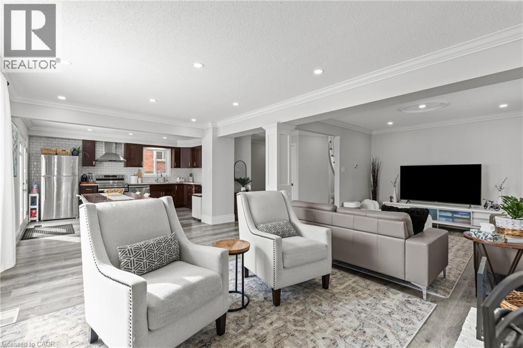 Open-concept living space featuring wood-finish flooring, recessed lighting, and crown molding - 27 Barbara Court, Hamilton, ON - Indoor Photo Showing Living Room