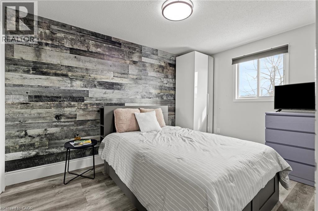 Accent wall featuring horizontal wood-finish paneling - 27 Barbara Court, Hamilton, ON - Indoor Photo Showing Bedroom