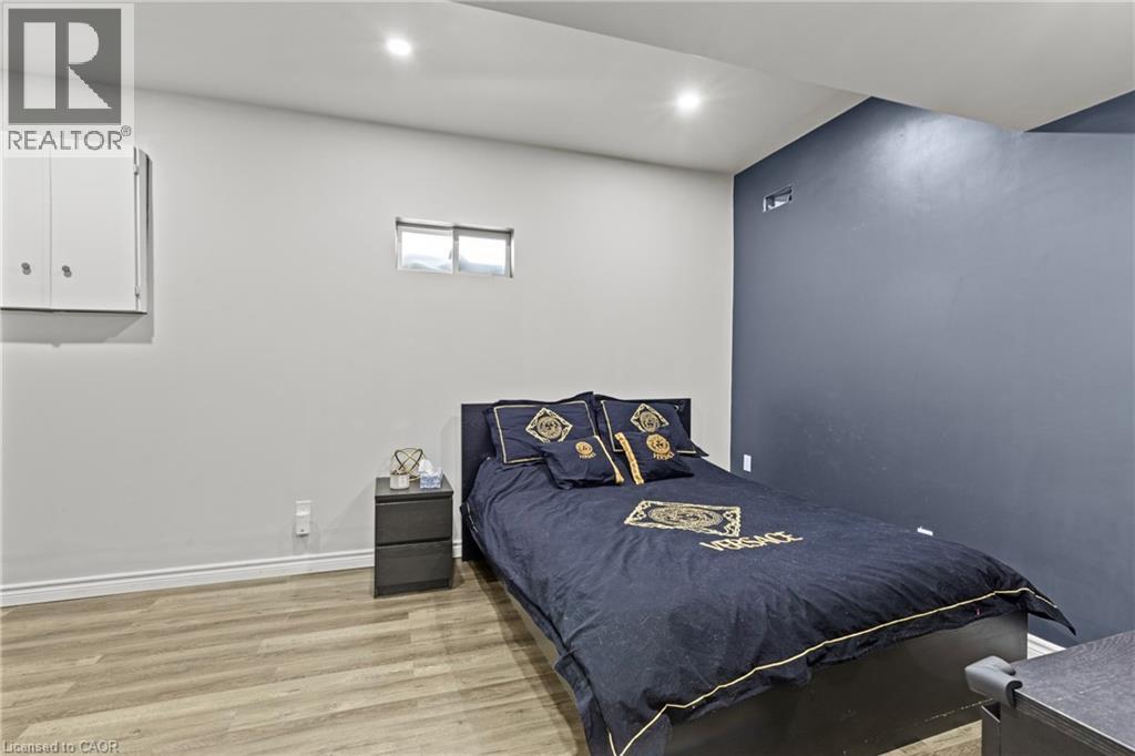 Bedroom featuring wood-finish flooring, recessed lighting, and a window for natural light - 27 Barbara Court, Hamilton, ON - Indoor Photo Showing Bedroom