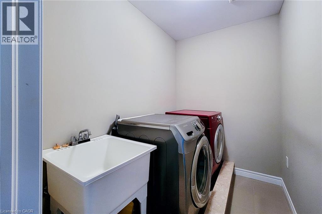Dedicated utility room featuring a large wash basin with chrome faucet and tile flooring - 40 Fairgrounds Drive, Binbrook, ON - Indoor Photo Showing Laundry Room