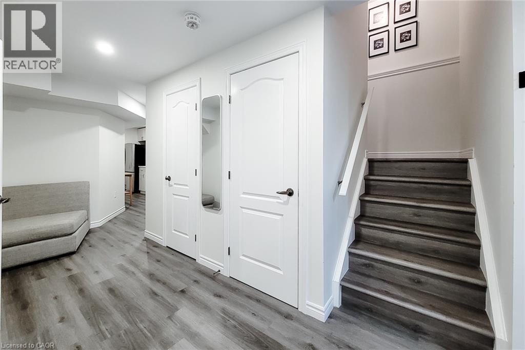 Staircase featuring wood-finish treads and risers, white handrail, and trim - 40 Fairgrounds Drive, Binbrook, ON - Indoor Photo Showing Other Room
