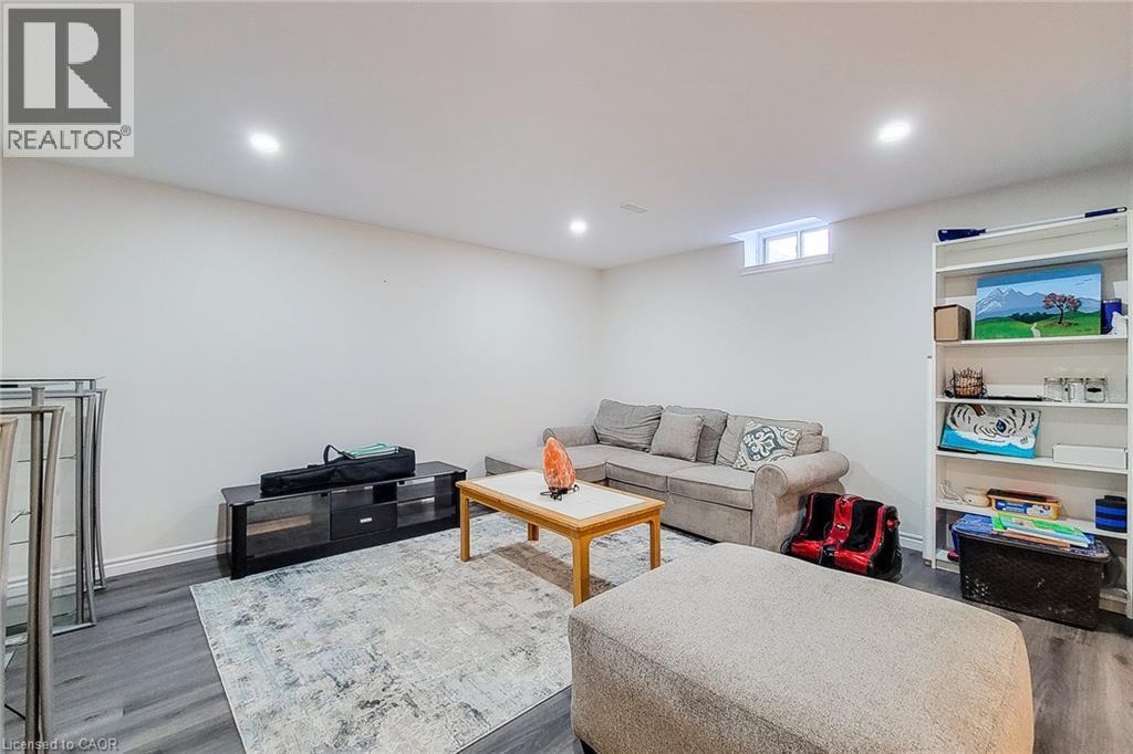Finished basement room featuring recessed lighting, wood-finish flooring, a built-in shelving unit, and a window for natural illumination - 40 Fairgrounds Drive, Binbrook, ON - Indoor Photo Showing Basement