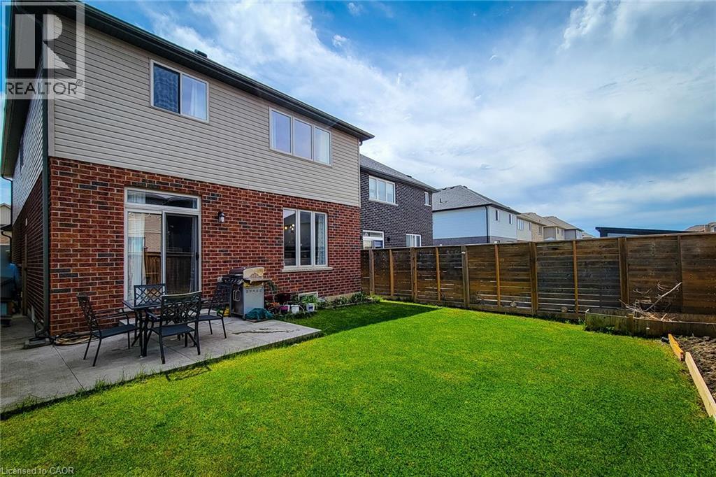 Expansive backyard featuring a manicured lawn, a concrete patio, and a privacy fence - 40 Fairgrounds Drive, Binbrook, ON - Outdoor With Exterior