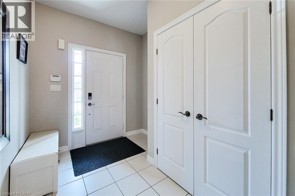 Entryway featuring white paneled doors, sidelight window, and tile flooring - 40 Fairgrounds Drive, Binbrook, ON - Indoor Photo Showing Other Room