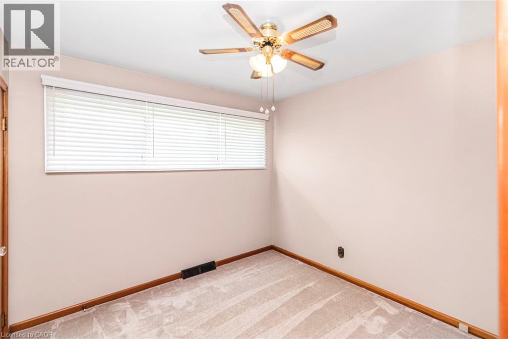 Room featuring neutral-toned carpeting, light-colored walls, and a ceiling fan with integrated lighting - 435 East 36Th Street, Hamilton, ON - Indoor Photo Showing Other Room