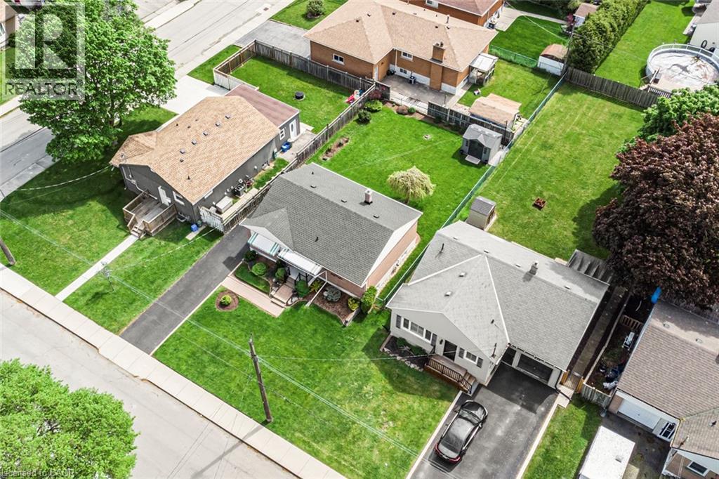 Residential property featuring a grey exterior, attached garage, and a long asphalt driveway - 435 East 36Th Street, Hamilton, ON - Outdoor With View