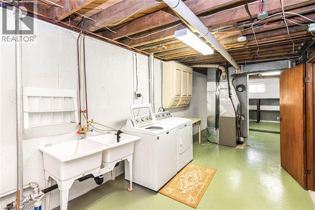 Utility space featuring a double basin sink, exposed ceiling joists, and painted concrete flooring - 435 East 36Th Street, Hamilton, ON - Indoor Photo Showing Laundry Room