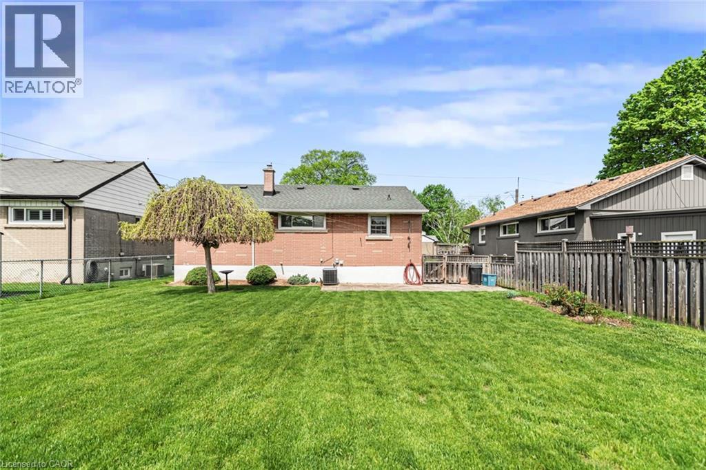 Expansive rear lawn featuring a mature weeping tree and established shrubbery - 435 East 36Th Street, Hamilton, ON - Outdoor