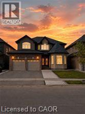 Stone and siding exterior featuring a double garage and concrete driveway - 85 Showcase Drive Unit# Main, Hamilton, ON - Outdoor With Facade