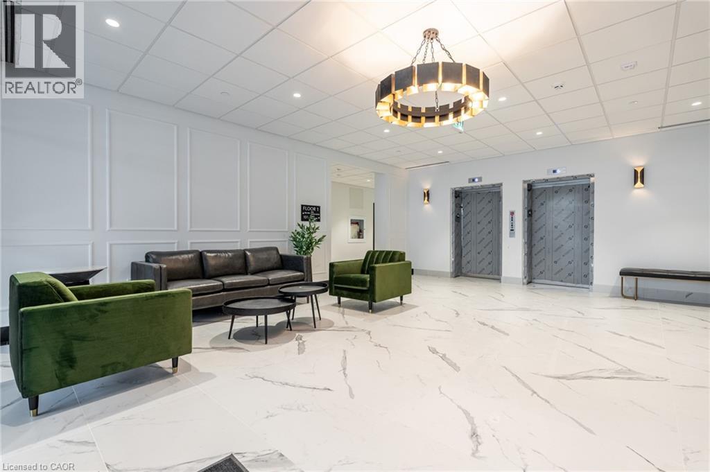 Spacious lobby featuring large format marble-look flooring and wainscoting - 1936 Rymal Road E Unit# 512, Hamilton, ON - Indoor Photo Showing Other Room