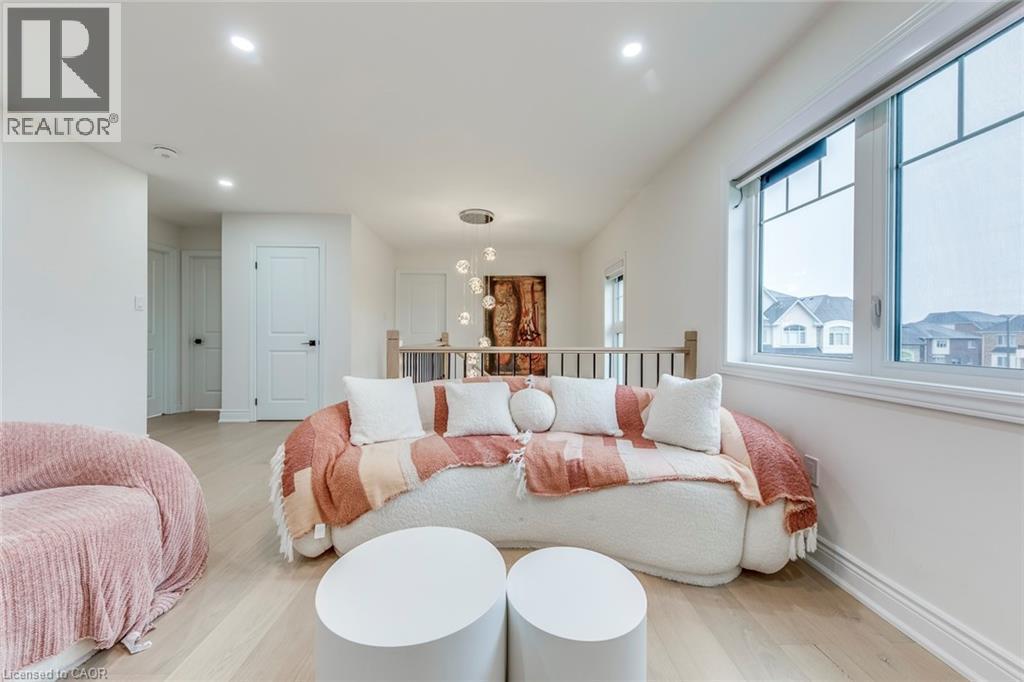 Upper-level landing featuring light wood-finish flooring, recessed lighting, white trim, and a large window with white framing - 3937 Leonardo Street, Burlington, ON - Indoor Photo Showing Dining Room