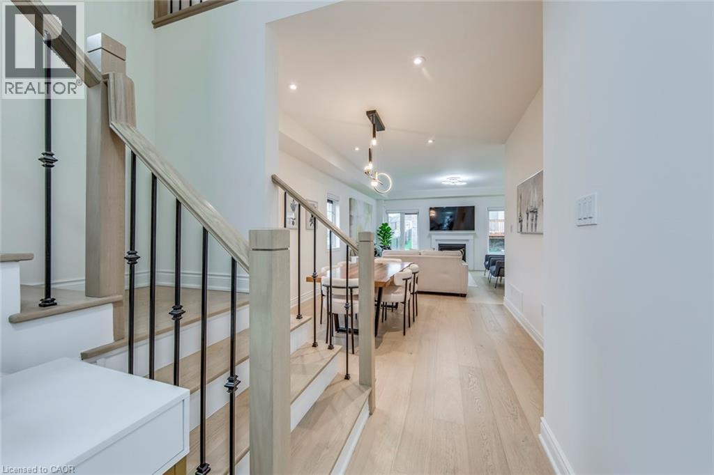 Hardwood flooring extends throughout this luminous entryway and main living area - 3937 Leonardo Street, Burlington, ON - Indoor Photo Showing Other Room
