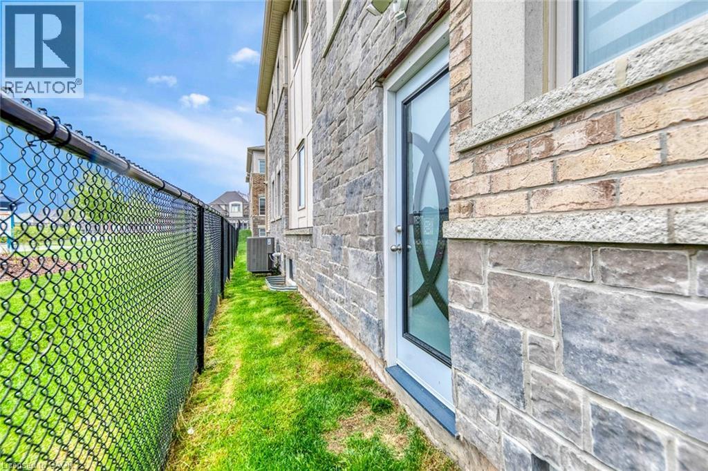 Exterior wall featuring mixed stone and brick cladding with a frosted glass door - 3937 Leonardo Street, Burlington, ON - Outdoor