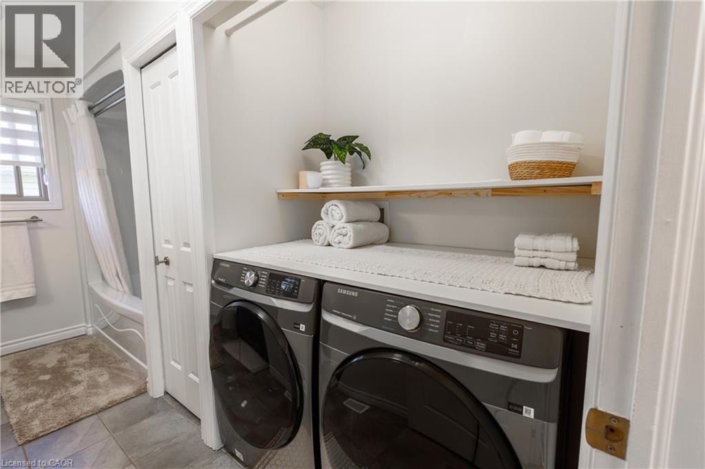 Dedicated laundry area featuring a white countertop with integrated shelving - 10 Redbud Crescent, Simcoe, ON - Indoor Photo Showing Laundry Room