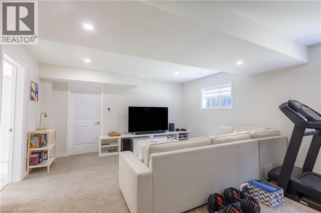 Finished lower level featuring recessed lighting, plush carpet flooring, a window with horizontal blinds, and a built-in media console - 10 Redbud Crescent, Simcoe, ON - Indoor