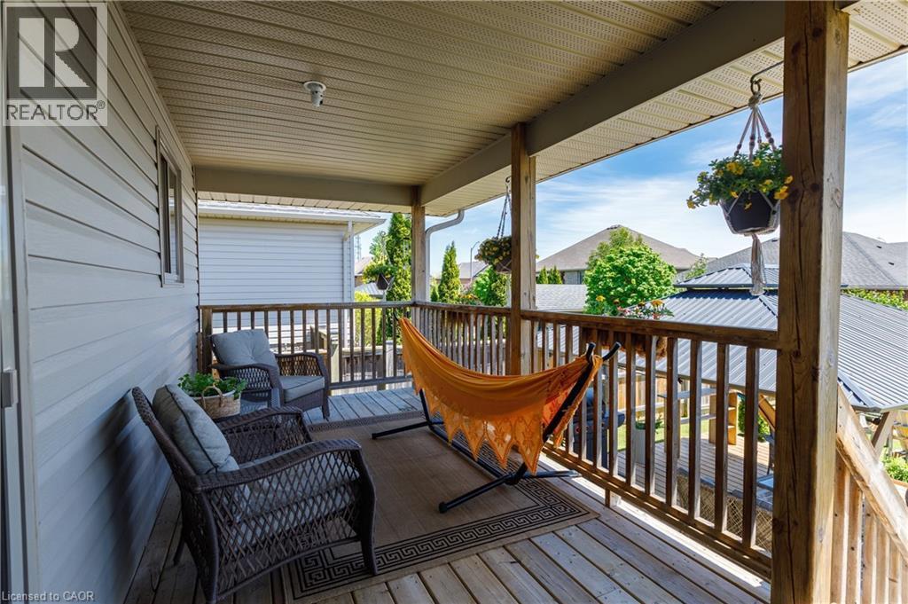 Expansive covered porch featuring wood decking, wood railings, and a horizontal siding exterior - 10 Redbud Crescent, Simcoe, ON - Outdoor With Deck Patio Veranda With Exterior