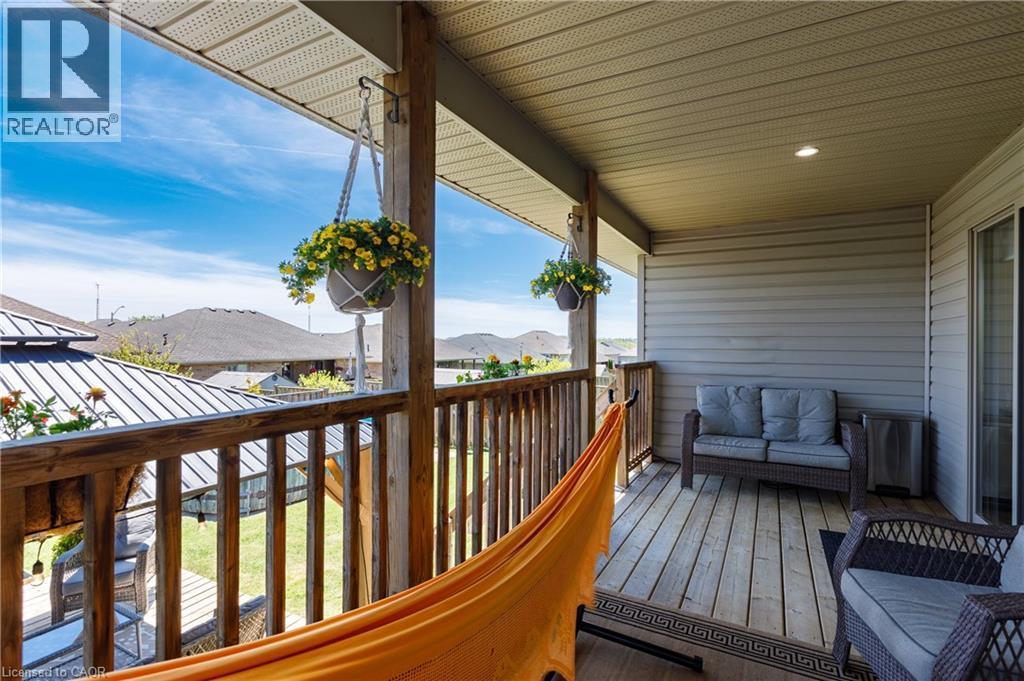 Expansive outdoor deck featuring wood-finish flooring, wood railings, and a vinyl soffit ceiling with recessed lighting - 10 Redbud Crescent, Simcoe, ON - Outdoor With Deck Patio Veranda With Exterior
