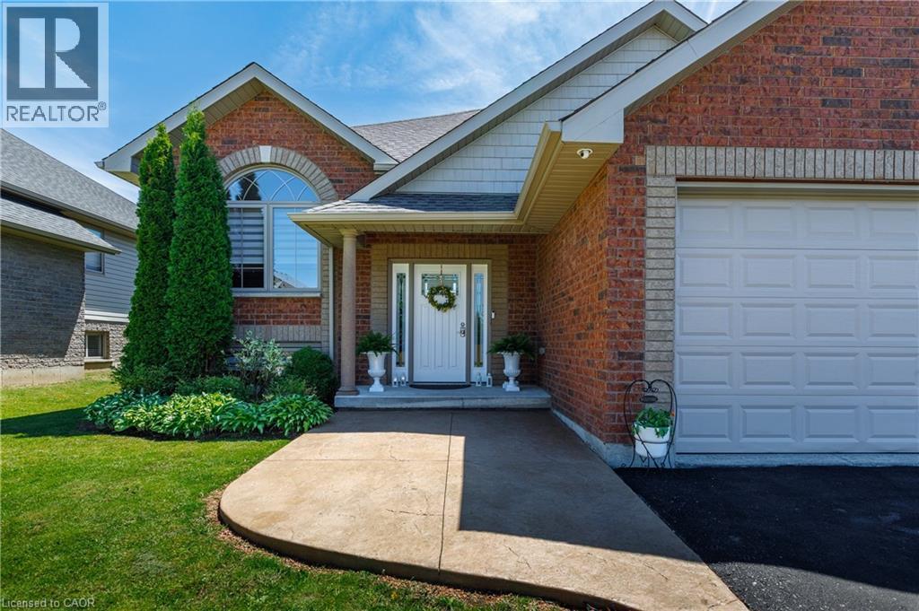 Brick exterior with a prominent arched window and a white paneled garage door - 10 Redbud Crescent, Simcoe, ON - Outdoor