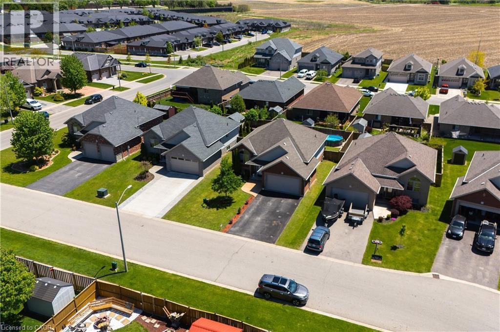 Residential neighborhood featuring single-family homes with attached garages, paved driveways, and manicured lawns - 10 Redbud Crescent, Simcoe, ON - Outdoor With View