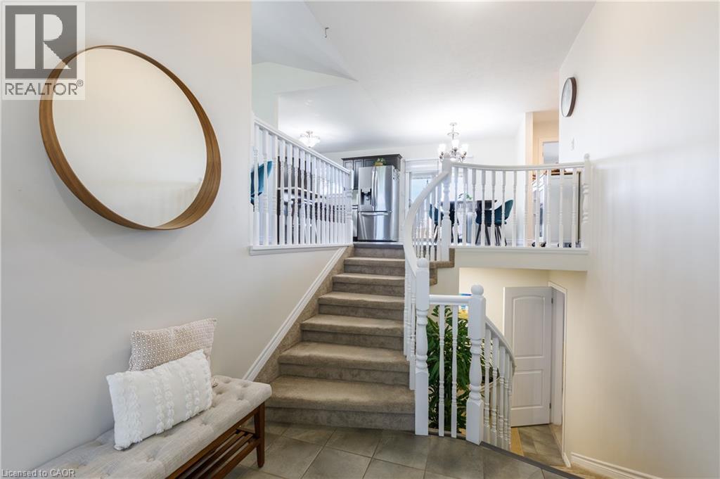 Split-level entry featuring a carpeted staircase with white balusters and handrails - 10 Redbud Crescent, Simcoe, ON - Indoor Photo Showing Other Room