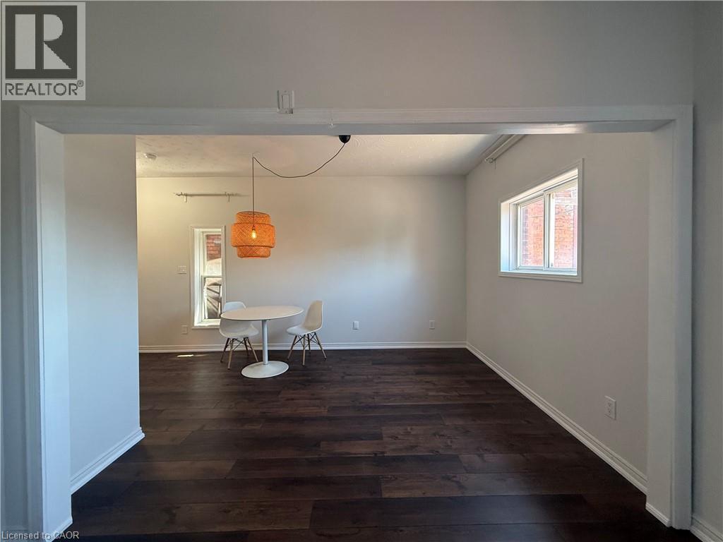 Open-concept living space featuring wide plank wood-finish flooring, light grey wall paint, and white trim - 359 Barton Street E Unit# Upper, Hamilton, ON - Indoor Photo Showing Other Room