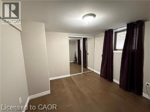 Room with wood-finish flooring, light grey painted walls, and white baseboards - 947 Main Street E Unit# 6, Hamilton, ON - Indoor